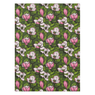 Blooming magnolia on dark green tablecloth