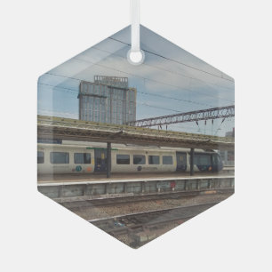 Blue and white train , in front of a building glass tree decoration