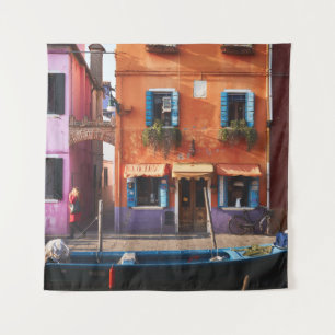 BLUE BOAT ON RIVER NEAR ORANGE BUILDING TAPESTRY