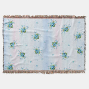 Blue forget-me-not's on a soft pink-blue throw blanket