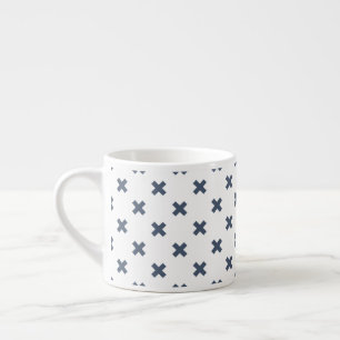 Blue-grey cross stitches on white espresso cup
