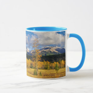 Blue skies and clouds above a meadow mug