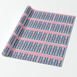 Blue skis on snow with pink background wrapping paper