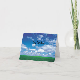 Blue sky with fluffy clouds and green grass card