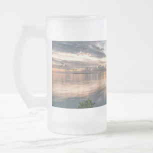 blue sky with red and dark clouds reflected on sea frosted glass beer mug