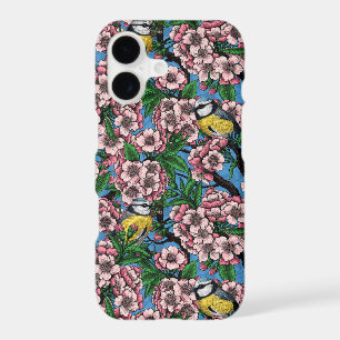 Blue tit birds in the blooming cherry tree on blue