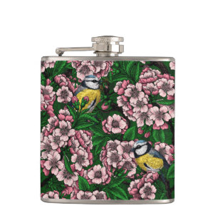 Blue tit birds in the blooming cherry tree on gree hip flask