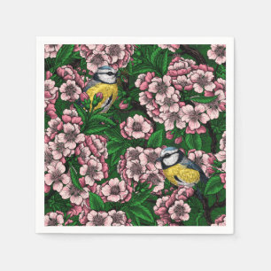 Blue tit birds in the blooming cherry tree on gree napkin