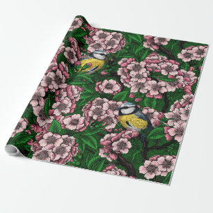 Blue tit birds in the blooming cherry tree on gree wrapping paper