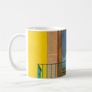 Blue wooden door on yellow concrete building coffee mug