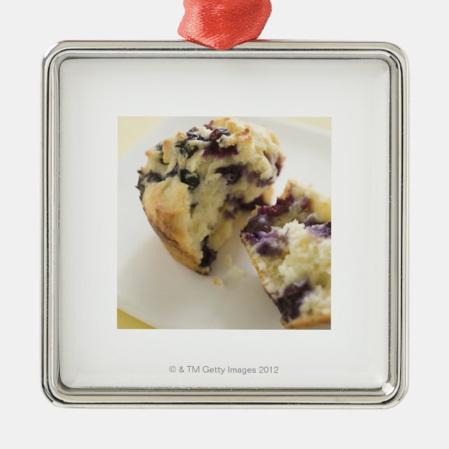 Blueberry muffin split open on a white plate metal tree decoration (Front)