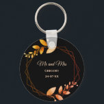 Boho autumn botanical gold frame wedding key ring<br><div class="desc">Set against a striking black background, this keychain features apricot-coloured text that provides a warm and inviting touch. Delicate leaves in soft muted earth tones and earthy autumnal copper shades evoke the cosy charm of autumn, while the geometric frame in burnt orange and terracotta adds a rustic yet sophisticated flair....</div>
