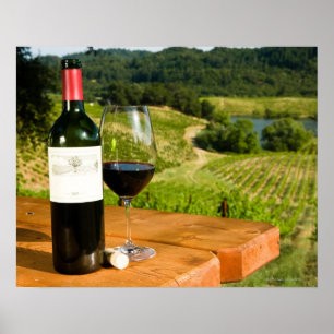 Bottle of red wine and glass on table poster