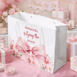 Bow She's tying the knot pink floral Bridal Shower Large Gift Bag<br><div class="desc">A white background decorated with a pink coloured bow and pink roses,  flowers. Personalise and add a name
Text: She's tying the knot.</div>