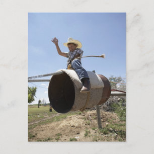 Boy (8-10) riding makeshift rodeo bull postcard