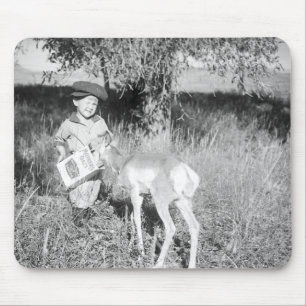 Boy feeding antelope by hand mouse mat