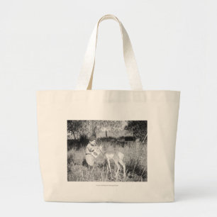 Boy feeding antelope large tote bag