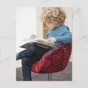 Boy reading a book postcard