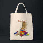 Boy toddler surrounded by books. tote bag<br><div class="desc">Toddler has taken all his books off the bookshelf and is busy reading them. Colourful books on the floor with an empty bookcase.</div>
