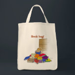 Boy toddler surrounded by books. tote bag<br><div class="desc">Toddler has taken all his books off the bookshelf and is busy reading them. Colourful books on the floor with an empty bookcase.</div>