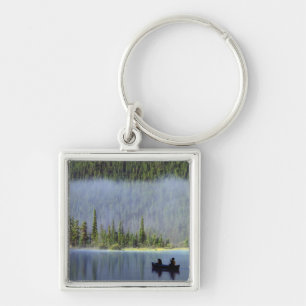 Boys fishing from canoe with mist in key ring