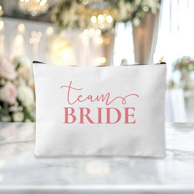 Bride - Team Bride! Gift Name  Accessory Pouch ("This Bride / Team Bride accessory and makeup bag showcases a sleek pink script font with elegant sw)