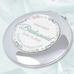 Bridesmaid Gift Elegant Teal & Silver Lace Compact Mirror<br><div class="desc">These compact mirrors are designed to give as favours to the bridesmaids in your wedding party. They feature a simple yet elegant design with a white background, teal or turquoise coloured script lettering, and a silver grey faux foil floral lace border. Perfect way to thank your bridesmaids for being a...</div>