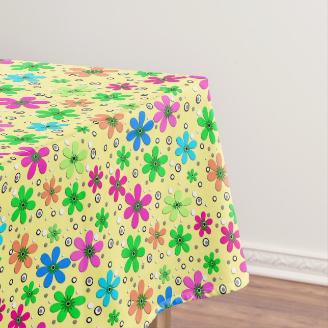 Bright multi-coloured chamomile flowers on a yello tablecloth (In Situ)