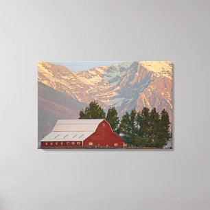 Bright red barn against Mission Mountains in Canvas Print