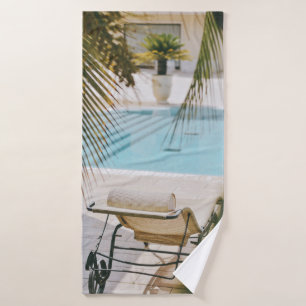 Brown and black armchair beside swimming pool in t bath towel