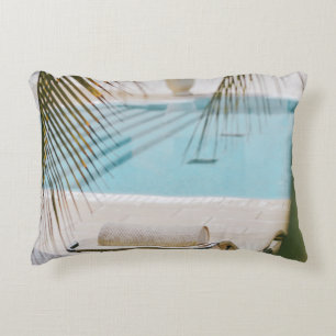 Brown and black armchair beside swimming pool in t decorative cushion