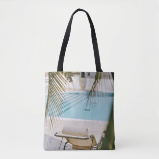 Brown and black armchair beside swimming pool in t tote bag