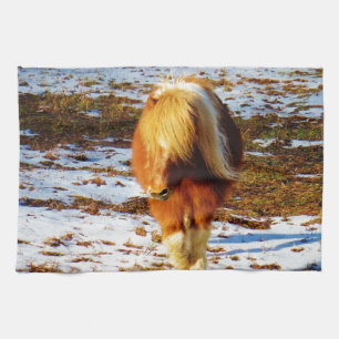 Brown and cream miniature horse in the snow. tea towel