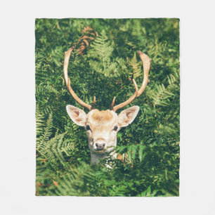 BROWN AND WHITE DEER SURROUNDED BY GREEN PLANTS FLEECE BLANKET