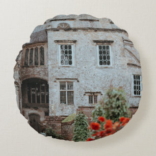 BROWN BRICKED HOUSE NEAR RED FLOWERS ROUND CUSHION