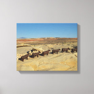 brown cows walking in desert canvas print