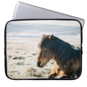BROWN HORSE SITTING ON GRASS NEAR BEACH LAPTOP SLEEVE