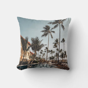 Brown wooden lounge chairs near pool surrounded by cushion