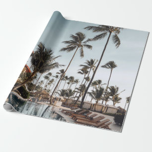 Brown wooden lounge chairs near pool surrounded by wrapping paper