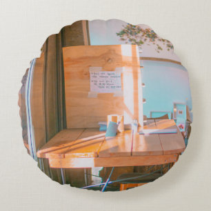 BROWN WOODEN TABLE WITH WHITE PRINTER PAPER ROUND CUSHION