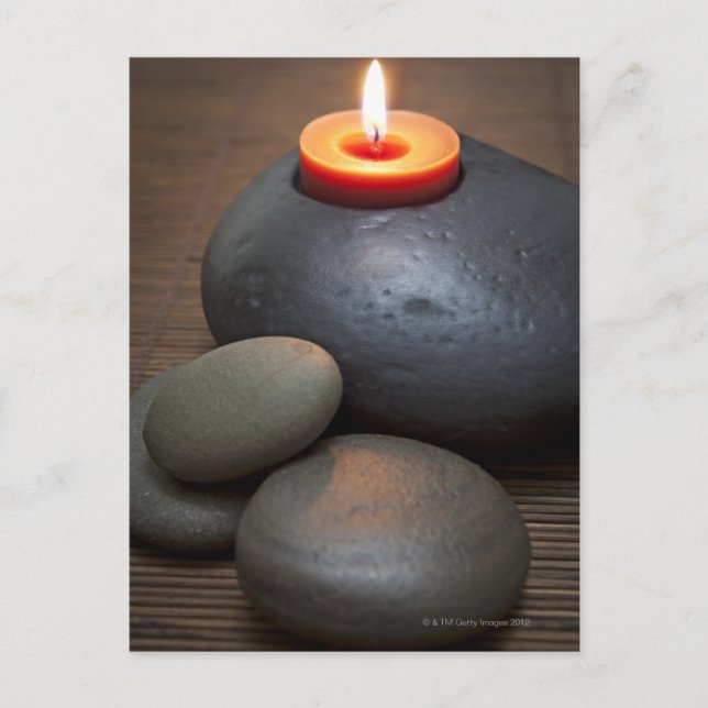 Burning candle flame with rocks in tranquil postcard (Front)