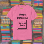 Business Hanukkah Greeting on Pink T-Shirt<br><div class="desc">Happy Hanukkah! Wishing you joy, peace and blessing this festival of lights. Holiday to celebrate this December and to advertise also your business. Pink t-shirt with Hanukkah greeting, your business name and logo. T-Shirt that you can include in your promotional products, giveaway items or gifts to your customers or clients...</div>