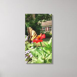 Butterfly on Flower in Front of House - Vertical Canvas Print