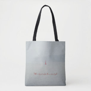 Calm winter sea and red lighthouse tote bag