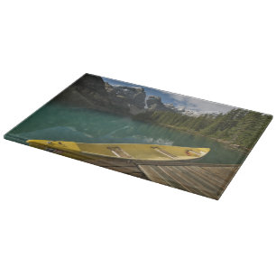 Canoe parked at a dock along Moraine Lake, Banff Cutting Board