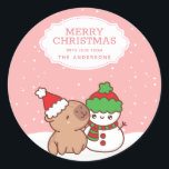 Capybara And Snowman Cute Merry Christmas Classic Round Sticker<br><div class="desc">Get into the Christmas spirit with our charming Capybara And Snowman Xmas Classic Sticker. Perfect for adding a touch of cuteness to your holiday decorations, this sticker showcases a capybara wearing a Santa hat and a snowman in a winter costume against a white and pink snow background. Personalise it with...</div>