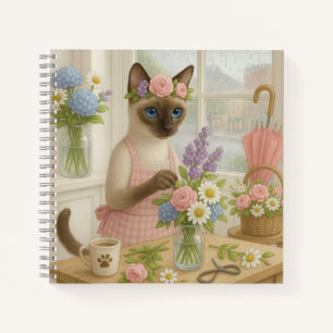 Cat arranging flower in florist notebook