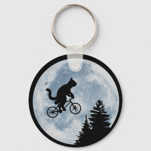 Cat is riding bicycle on the moon background. key ring