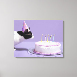 Cat wearing birthday hat blowing out candles canvas print