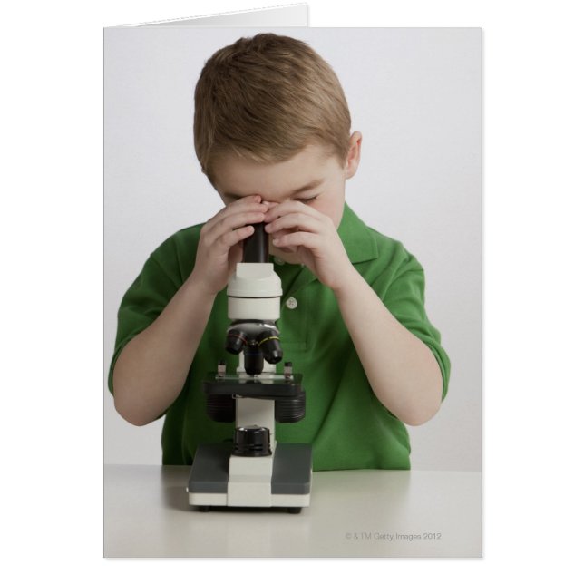 Caucasian boy peering into microscope (Front)